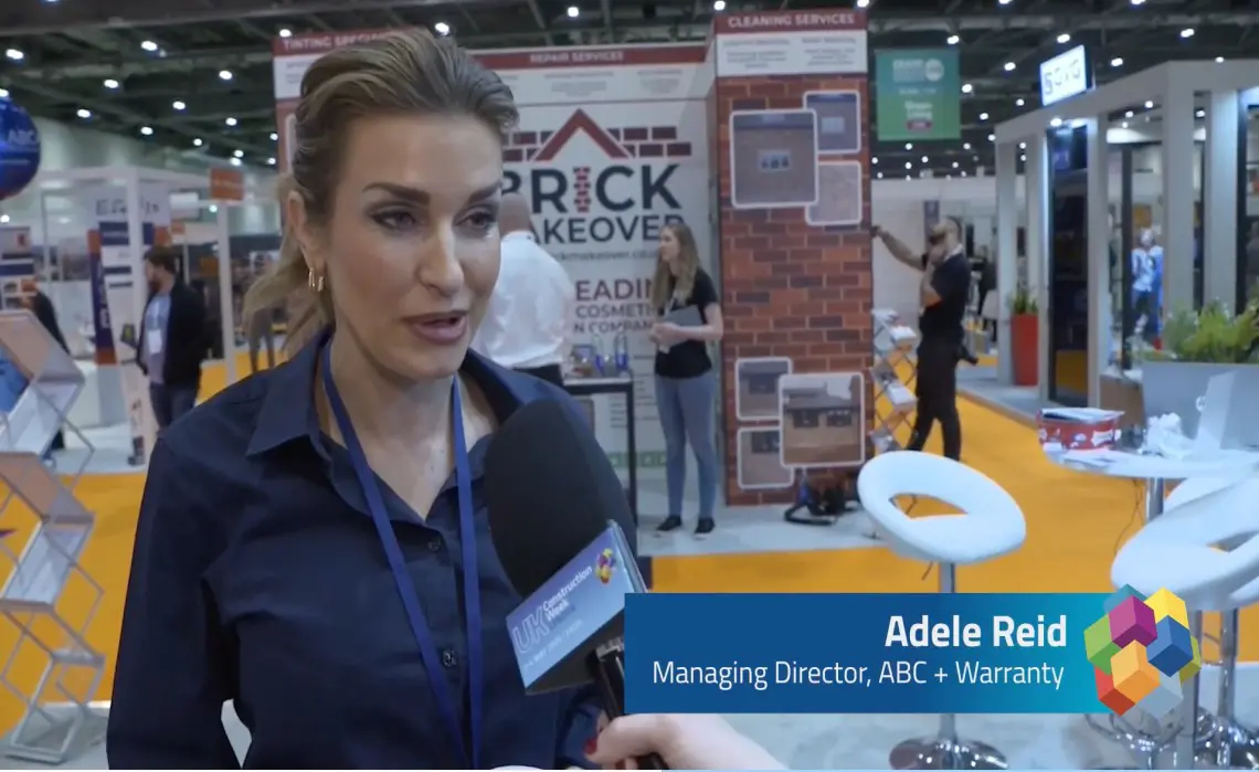 A woman talking to an interviewer at a trade show.