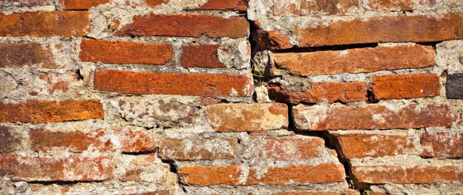An old brick wall with cracks in it.