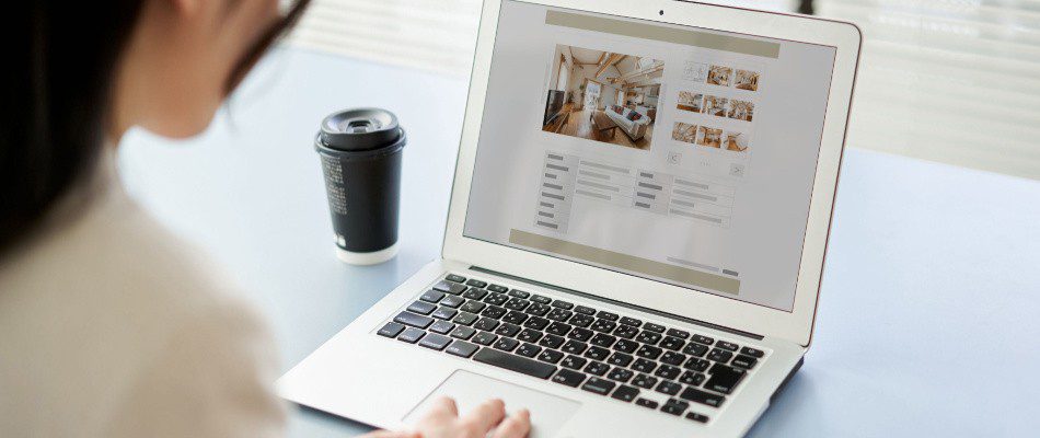 A woman is using a laptop with a picture on it.