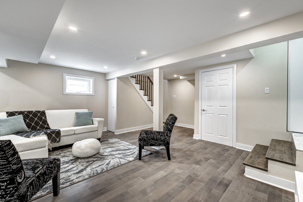 A living room with a white couch and stairs.