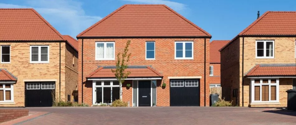 A row of brick homes with garages and driveways.